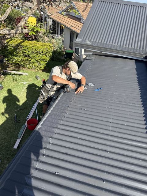 Carpenter fixing new metal roof sheets